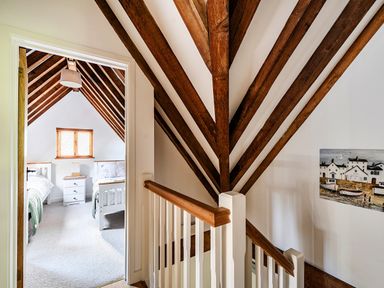 A staircase leading to a bedroom with a window and two beds at Cabin Sleeps 6 with Parking and Patio, Tremail near Camelford