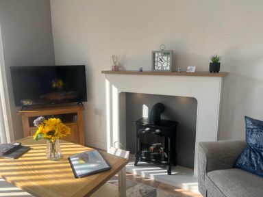 A living room with a television and fireplace at The Old Barn in Bridlington