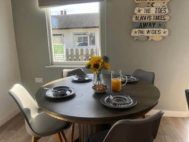 A dining room with a round table set for a meal at The Old Barn in Bridlington