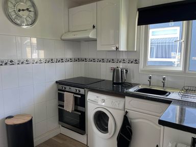 A kitchen with an oven, washing machine, and sink at The Old Barn in Bridlington