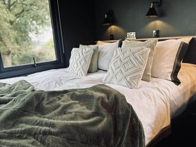 A bedroom with a bed and pillows at The Old Barn in Newton Abbot
