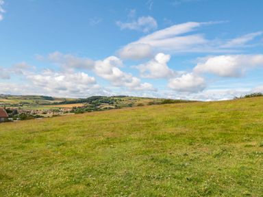 A field with grass and distant hills at Owls Roost in Robin Hood’s Bay