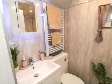 A bathroom with a sink, toilet, and towel rail at Owls Roost in Robin Hood’s Bay