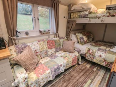 A bedroom with a sofa and bunk beds at Owls Roost in Robin Hood’s Bay