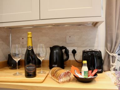 A kitchen with prosecco and glasses on the counter at Owls Roost in Robin Hood’s Bay