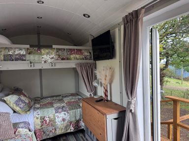 A bedroom with a bed and shelves at Owls Roost in Robin Hood’s Bay