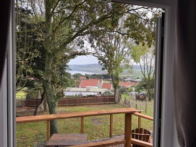A view of trees and houses from a window at Owls Roost in Robin Hood’s Bay