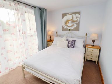 A bedroom with a bed and bedside tables at Alma House in Seahouses