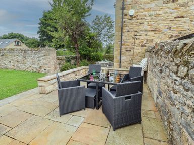 An outdoor patio area with a table and chairs at Alma House in Seahouses