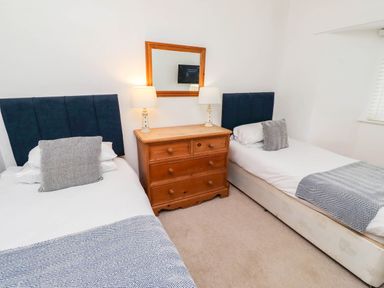 A bedroom with two beds and a dresser at Spinnaker