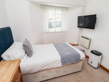 A bedroom with a bed and a television at Spinnaker 