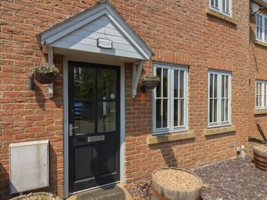 An entrance with a front door and windows at Over Carr Cottage in Malton
