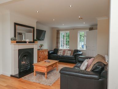 A living room with a fireplace and sofas at The Cosy Haven in Malton