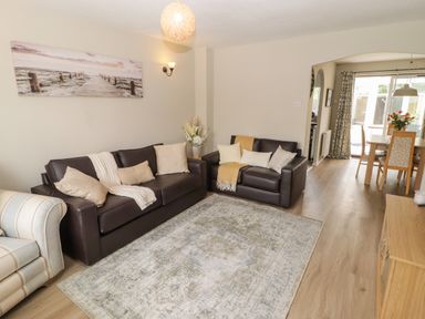 A living room with a sofa and a dining table at 7 Cwrt Y Cadno Llantwit Major