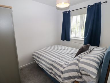 A bedroom with a bed and curtains at 7 Cwrt Y Cadno in Llantwit Major