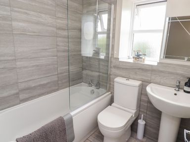 A bathroom with a bathtub, shower, toilet, and sink at 7 Cwrt Y Cadno in Llantwit Major