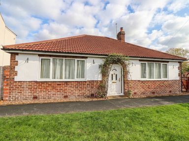 A house with a brick exterior and a front lawn at Westgate Willows in Nafferton