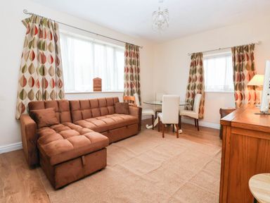 A living room with a sofa and dining area at Westgate Willows Nafferton