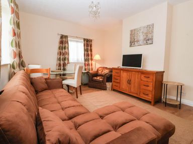 A living room with a sofa and television at Westgate Willows in Nafferton