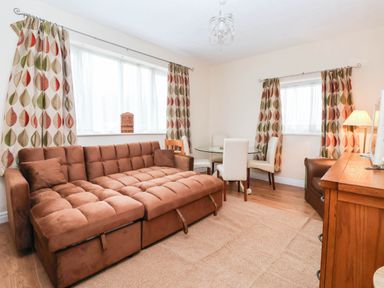 A living room with a sofa and dining table at Westgate Willows in Nafferton