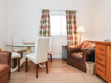 A dining room with a glass table and white chairs at Westgate Willows in Nafferton