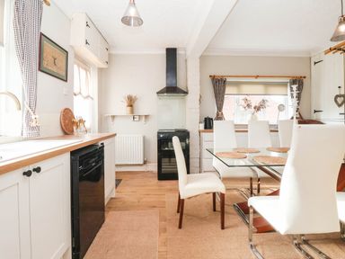 A kitchen with a table and chairs at Westgate Willows in Nafferton