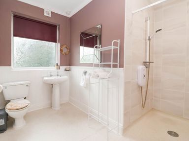 A bathroom with a toilet, sink, shower, and towel rack at Westgate Willows in Nafferton
