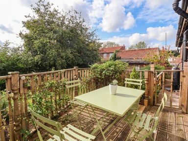 An outdoor area with a green table and chairs at Westgate Willows Nafferton