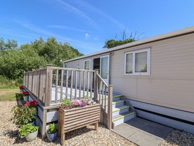 An exterior view of a mobile home with steps and railings at The Hideaway in Portesham