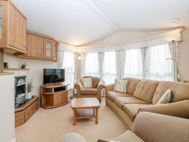A living room with a sofa and television at The Hideaway in Portesham