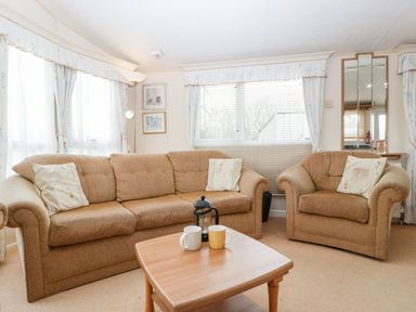A living room with a sofa and armchair at The Hideaway in Portesham