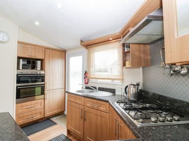 A kitchen with cabinets and appliances at The Hideaway in Portesham