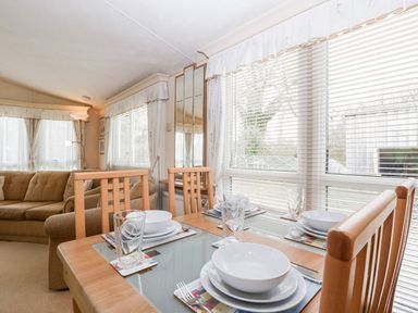 A dining room with a table set for a meal at The Hideaway in Portesham