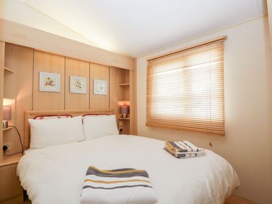 A bedroom with a bed and wall art at The Hideaway in Portesham
