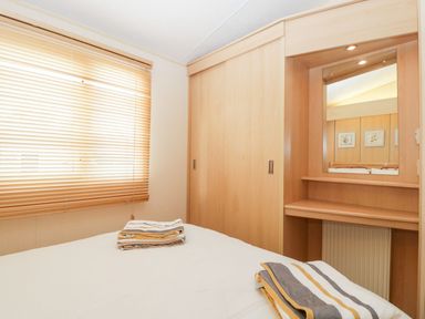 A bedroom with bed and mirror at The Hideaway in Portesham