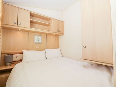 A bedroom with a bed and cabinetry at The Hideaway in Portesham