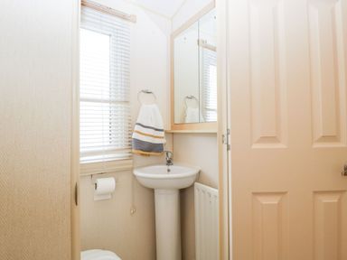 A bathroom with a sink, mirror, and towel rack at The Hideaway in Portesham