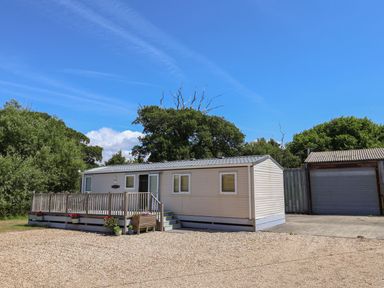 A mobile home with a deck and garage at The Hideaway in Portesham