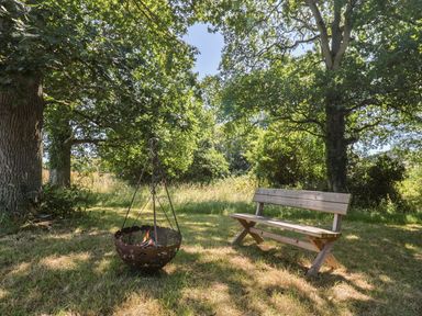 A garden with a bench and fire pit at The Hideaway in Portesham