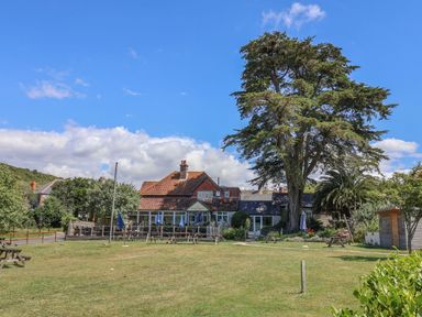 An outdoor area with a house and seating at The Hideaway in Portesham