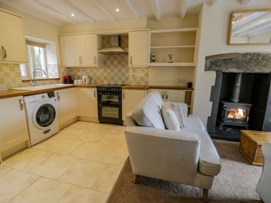 A kitchen with appliances and a sofa at Awelfryn in Betws-y-Coed