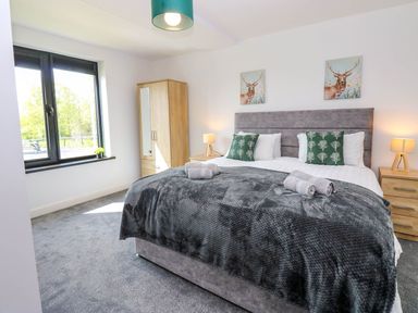A bedroom with a bed and wardrobe at Sycamore Cottage in Frizington