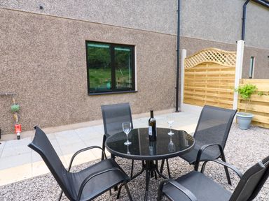 A patio area with a table and chairs at Sycamore Cottage in Frizington