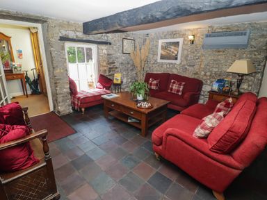 A living room with red sofas and a coffee table at Ty Mawr Country House in Carmarthen