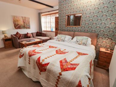 A bedroom with a bed, sofa and table at Ty Mawr Country House in Carmarthen
