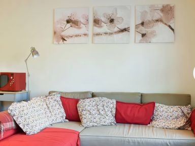 A living room with a sofa and paintings at Admirals Rest in Weymouth