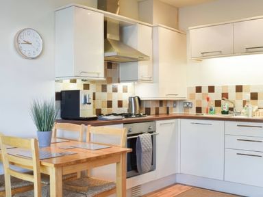 A kitchen with a table and chairs at Admirals Rest in Weymouth