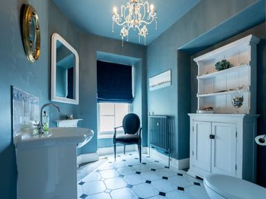 A bathroom with a sink, toilet, and cupboard at Gwynfryn House in Llanbedr