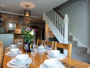 A dining room with a table set for a meal at Gwynfryn House in Llanbedr
