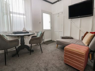 A living room with a table and chairs at 1 St. Day Road in Redruth
